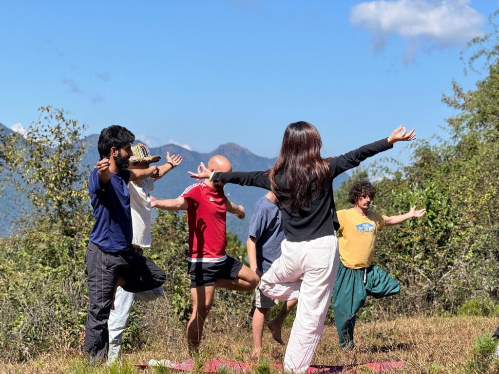 Yoga instructor leading an outdoor yoga session with Himalayan views.